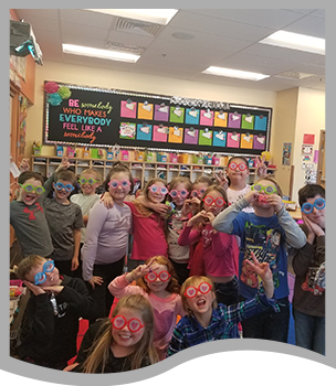 Students wear silly glasses and pose together